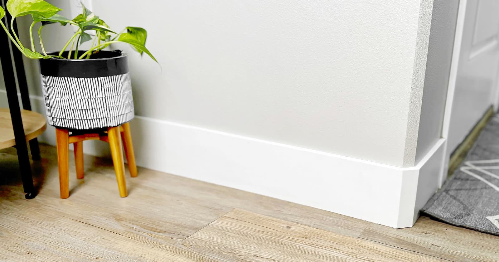 White Baseboards on Grey Walls with Wood Flooring and House Plant